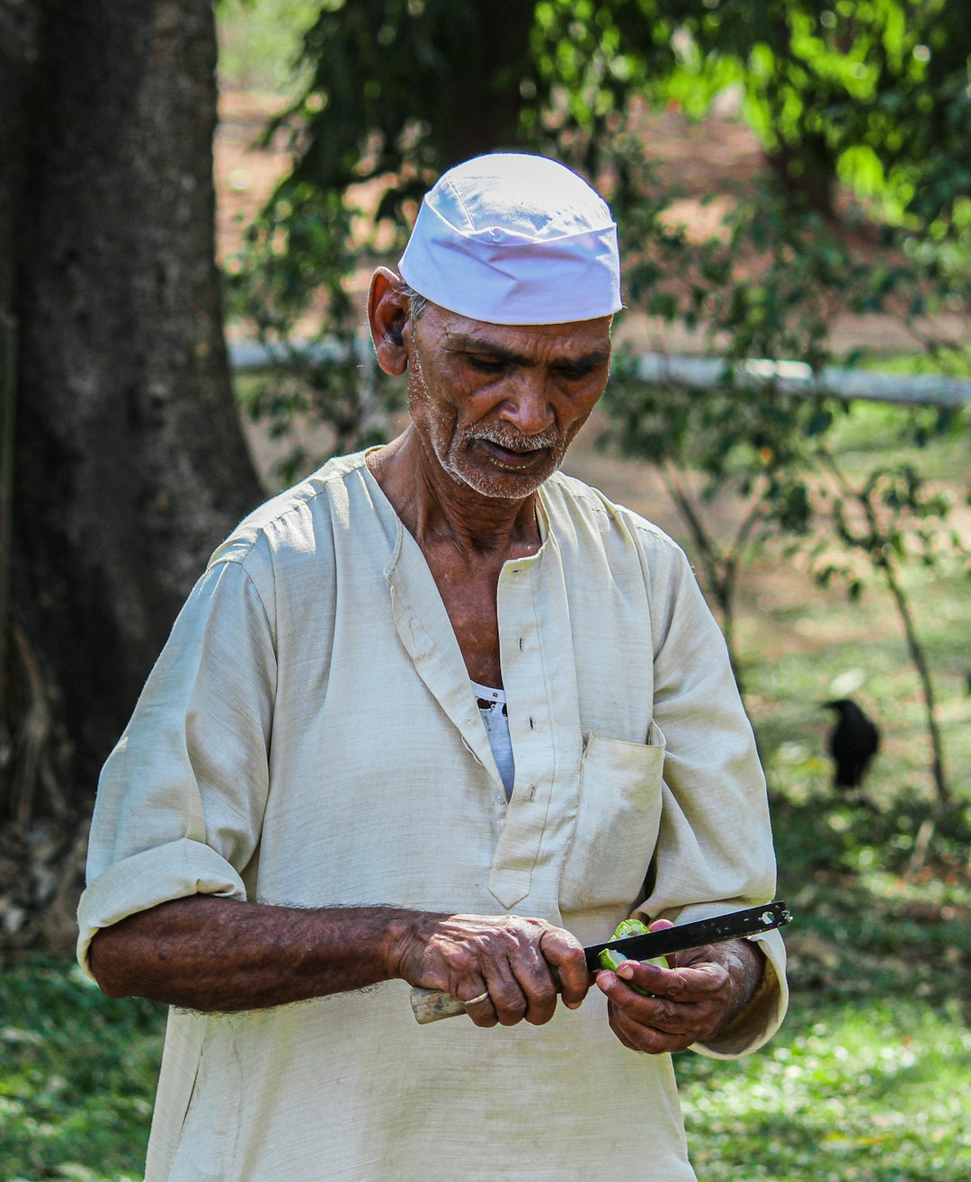 man in white polo shirt holding black sunglasses