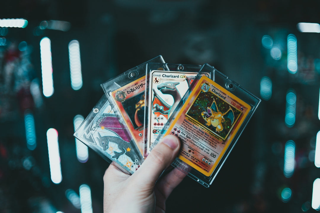 a person holding three pokemon cards in their hand