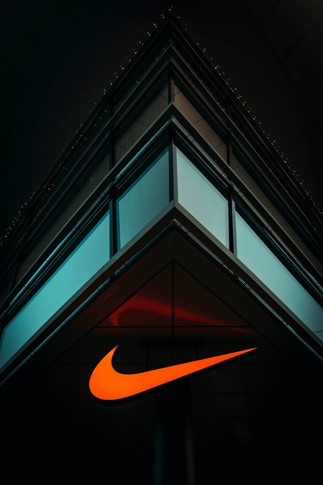 the nike logo is lit up on the side of a building