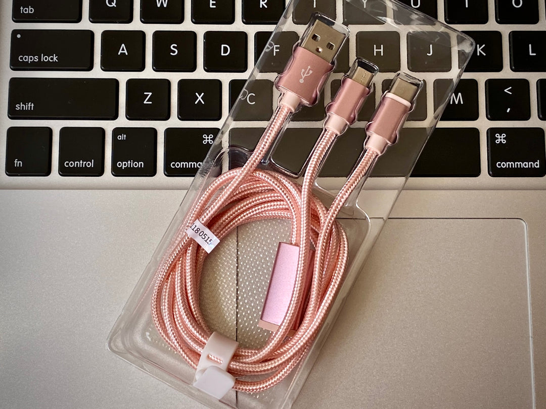 a couple of pink cables sitting on top of a laptop