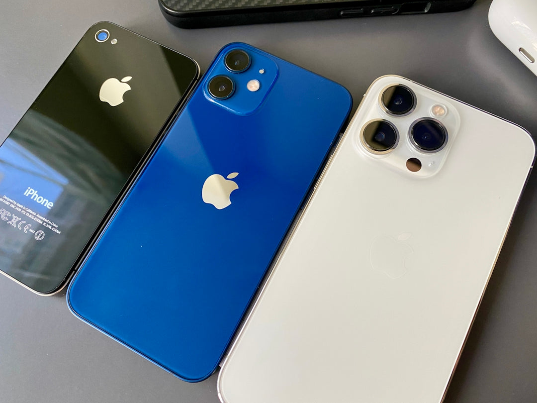 three different colored iphones sitting next to each other