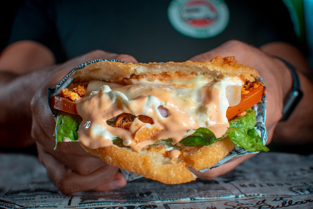 a person holding a sandwich in their hand