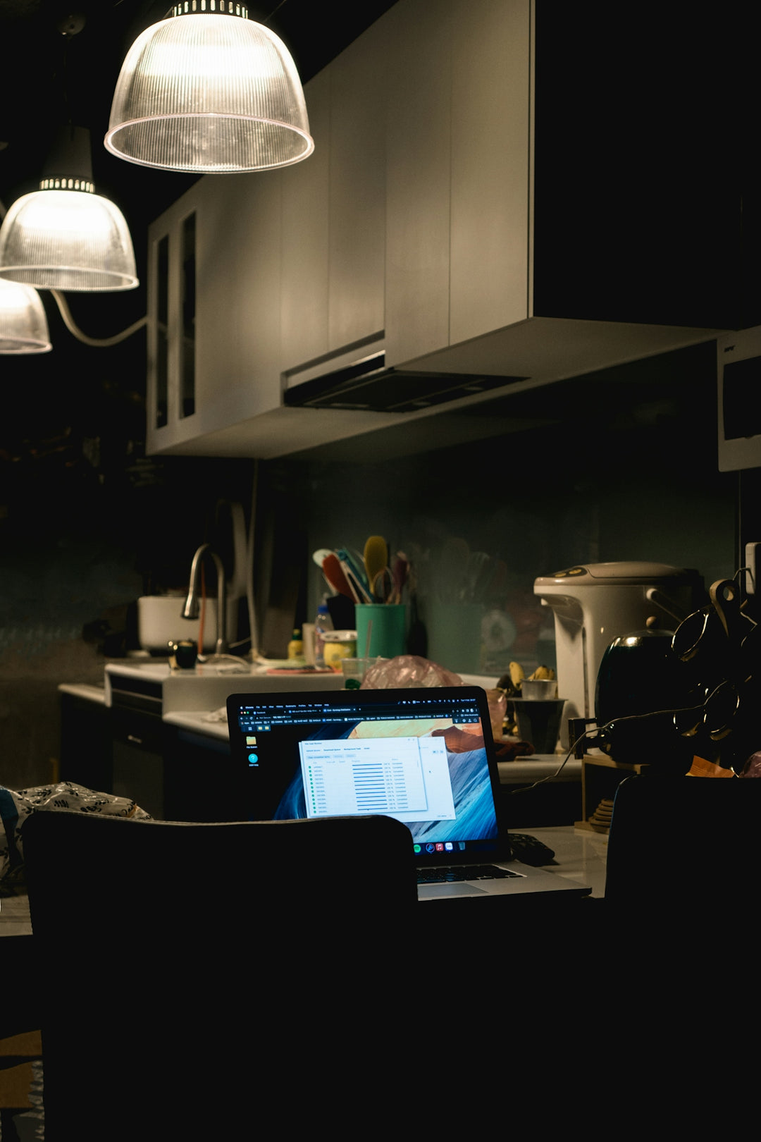 a laptop computer sitting on top of a kitchen counter