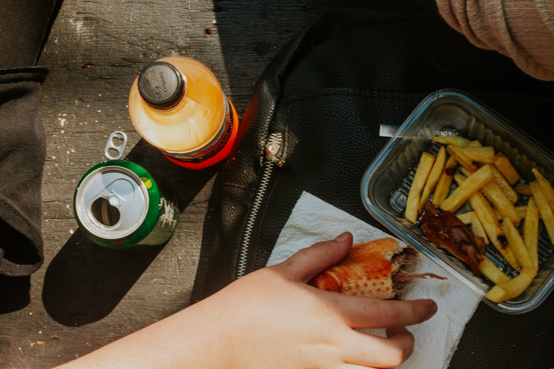 a person holding a sandwich and french fries