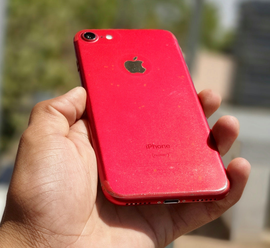 a person holding a red iphone in their hand