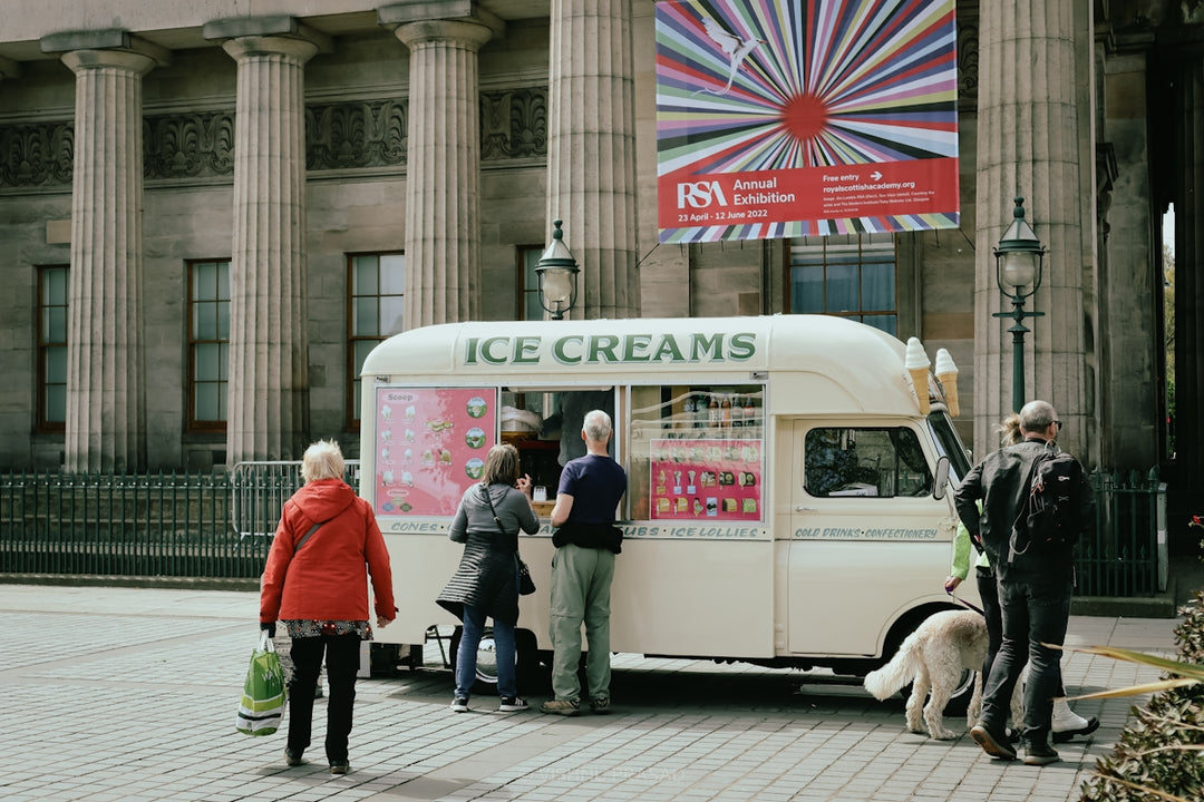 a group of people standing in front of a ice cream truck