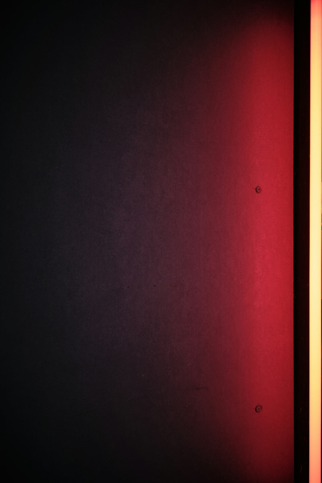 a dark room with a red light on the wall