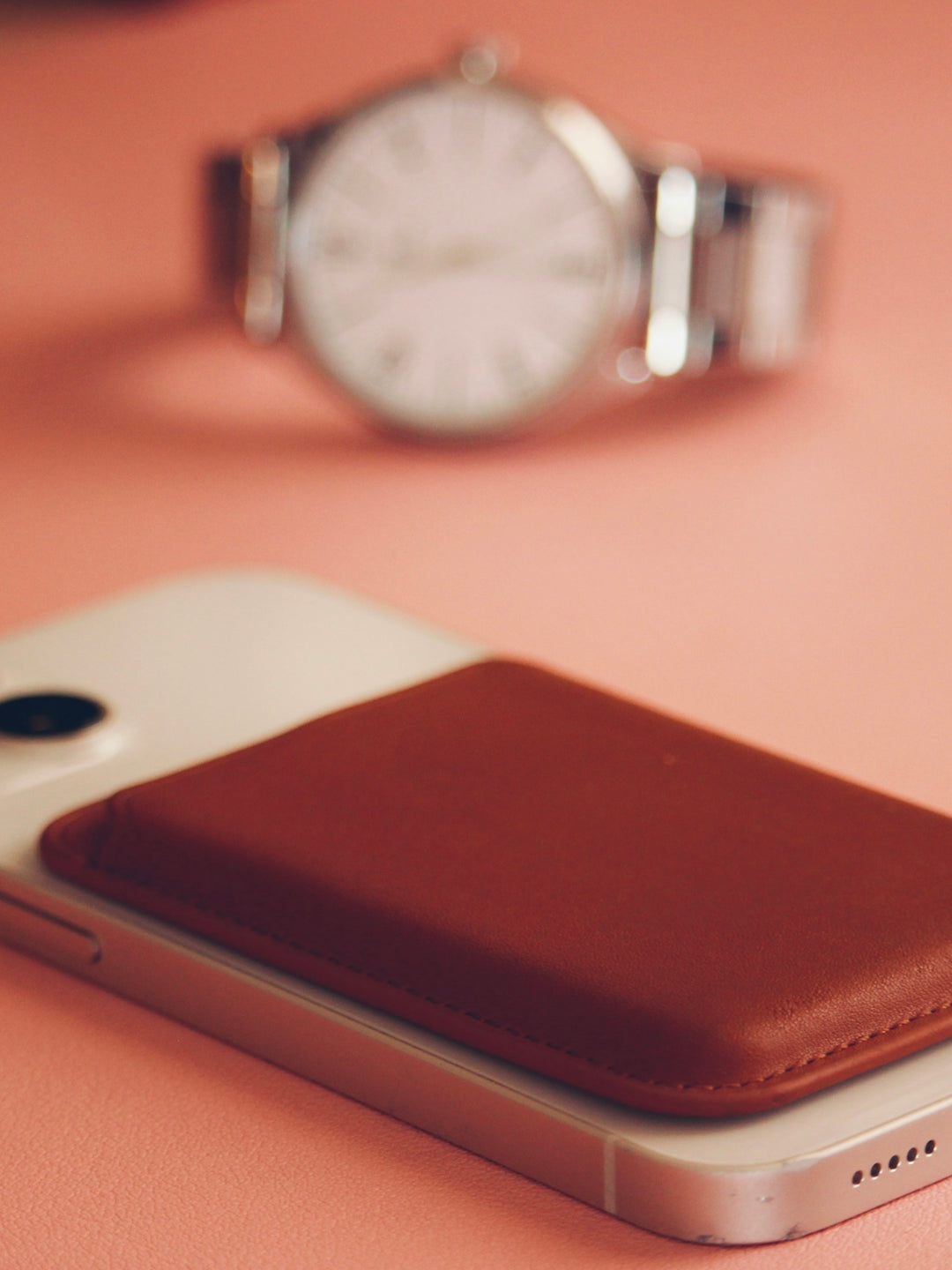 a cell phone sitting on top of a table next to a watch