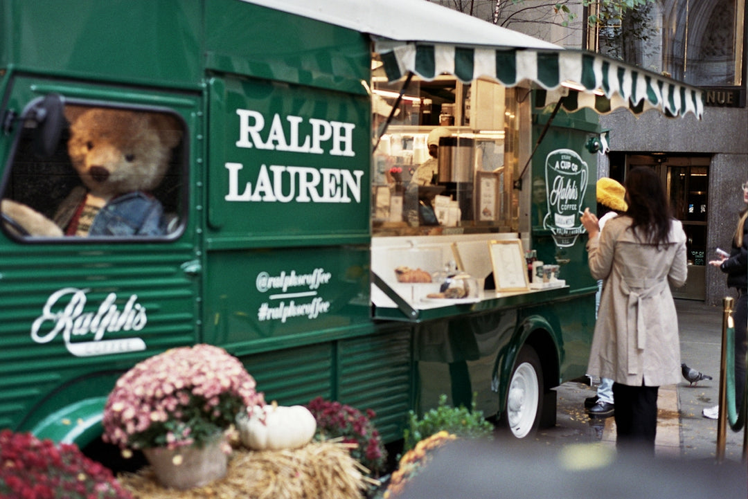 a woman standing next to a green food truck