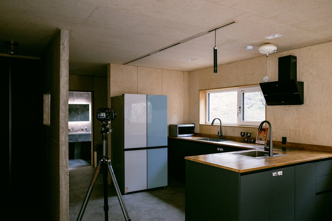 a kitchen with a sink a refrigerator and a tripod
