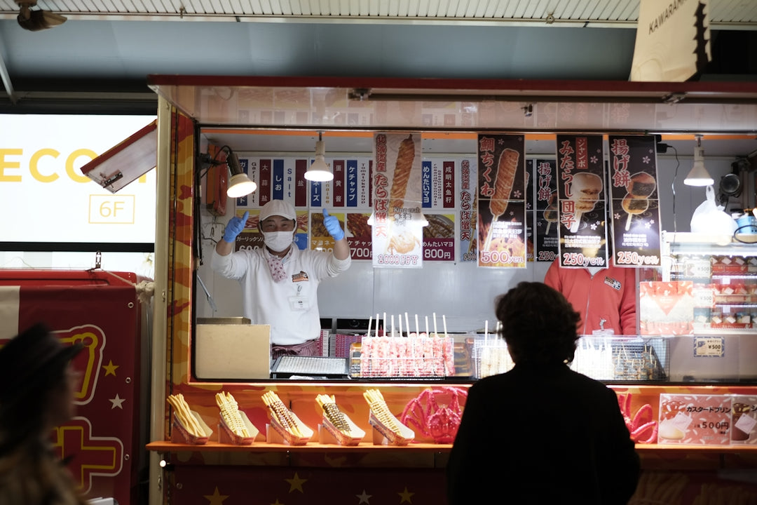 a person standing in front of a food stand