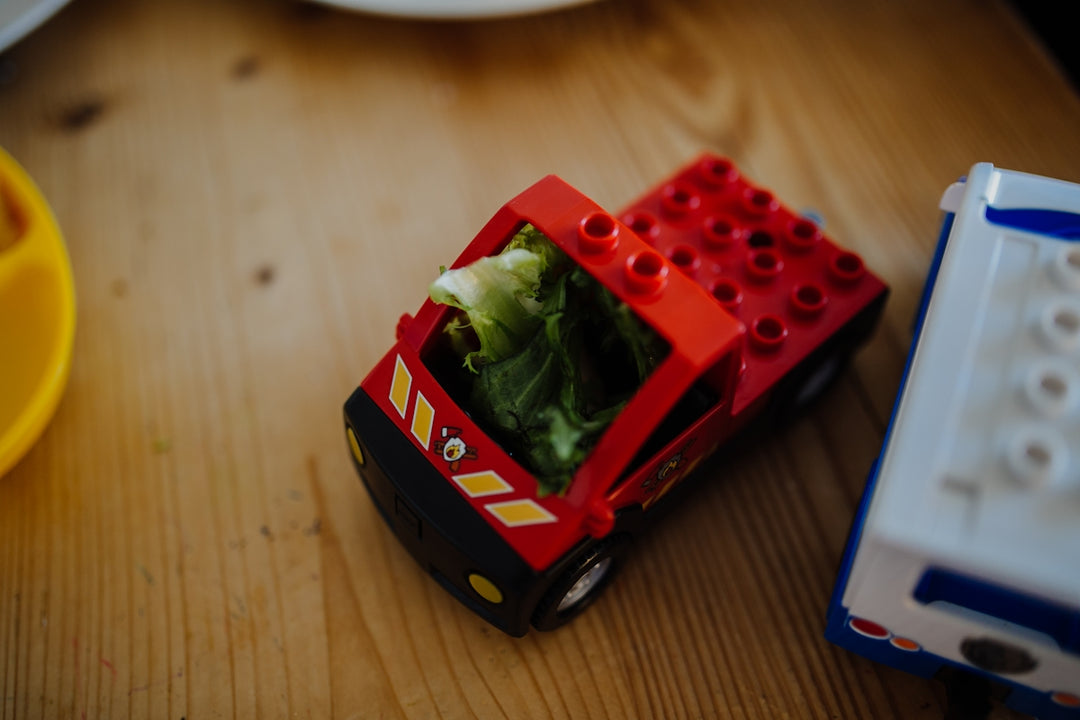 a toy truck with lettuce inside of it