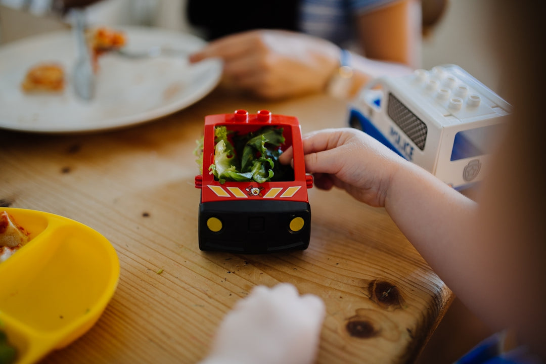 a child is playing with a toy fire truck