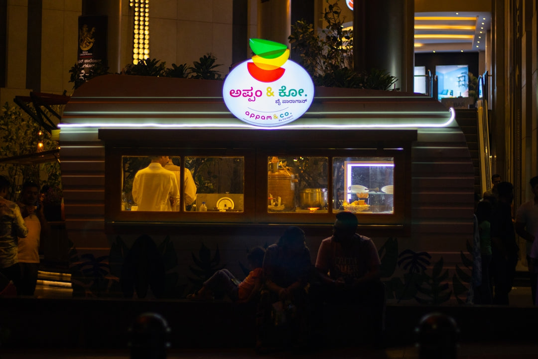 a group of people standing outside of a store at night