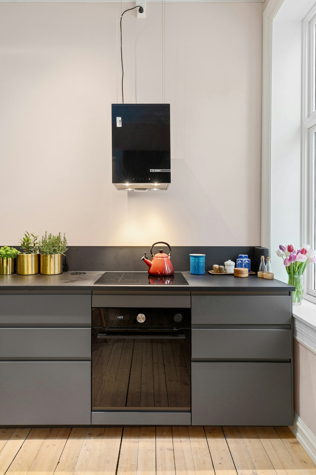 A kitchen with a stove, sink, and window