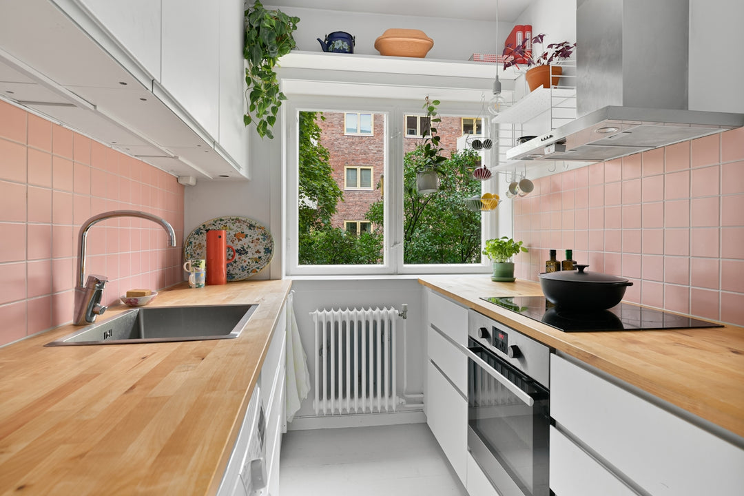 A kitchen with a wooden counter top and white cabinets