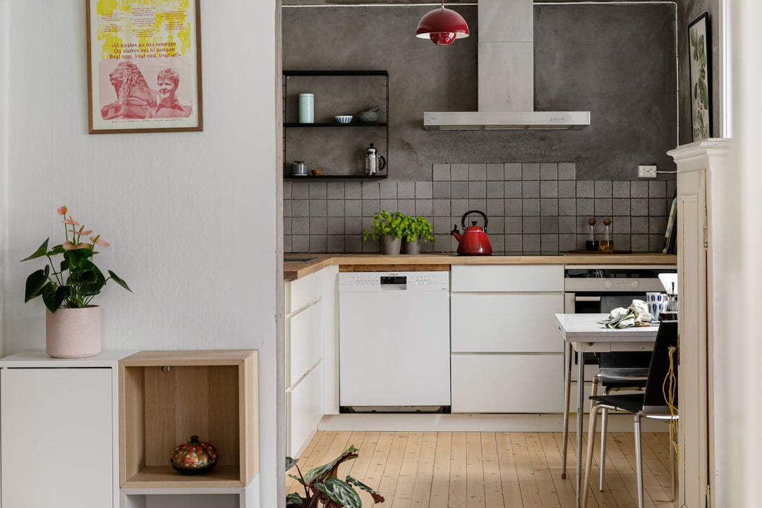 A kitchen with white cabinets and a wooden floor