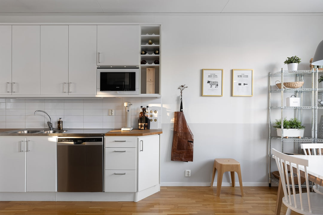 A kitchen with white cabinets and wooden floors