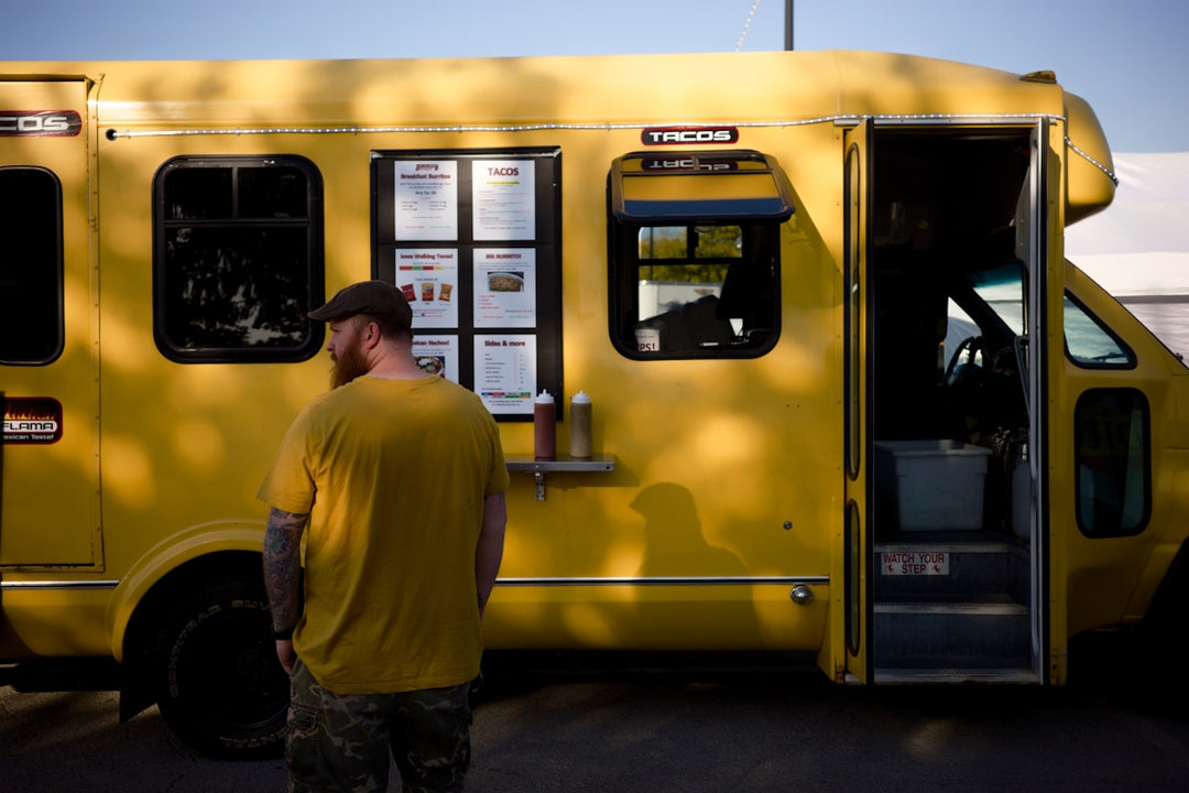 A man standing in front of a yellow food truck