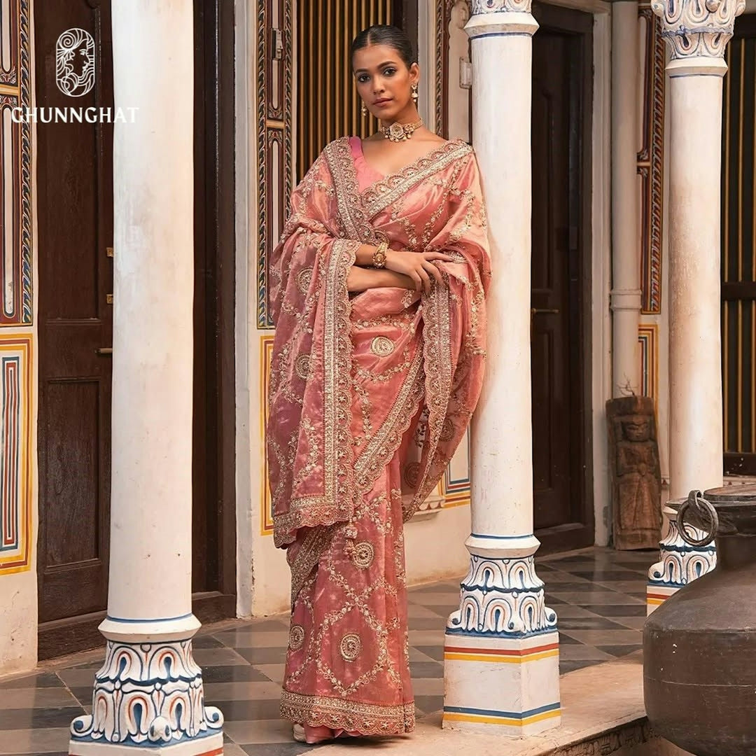 A woman in a pink sari standing on a porch