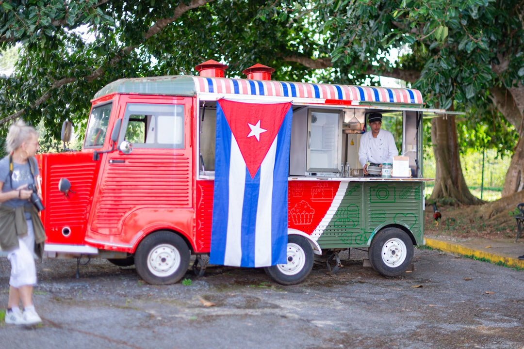 A red and green food truck parked in a parking lot