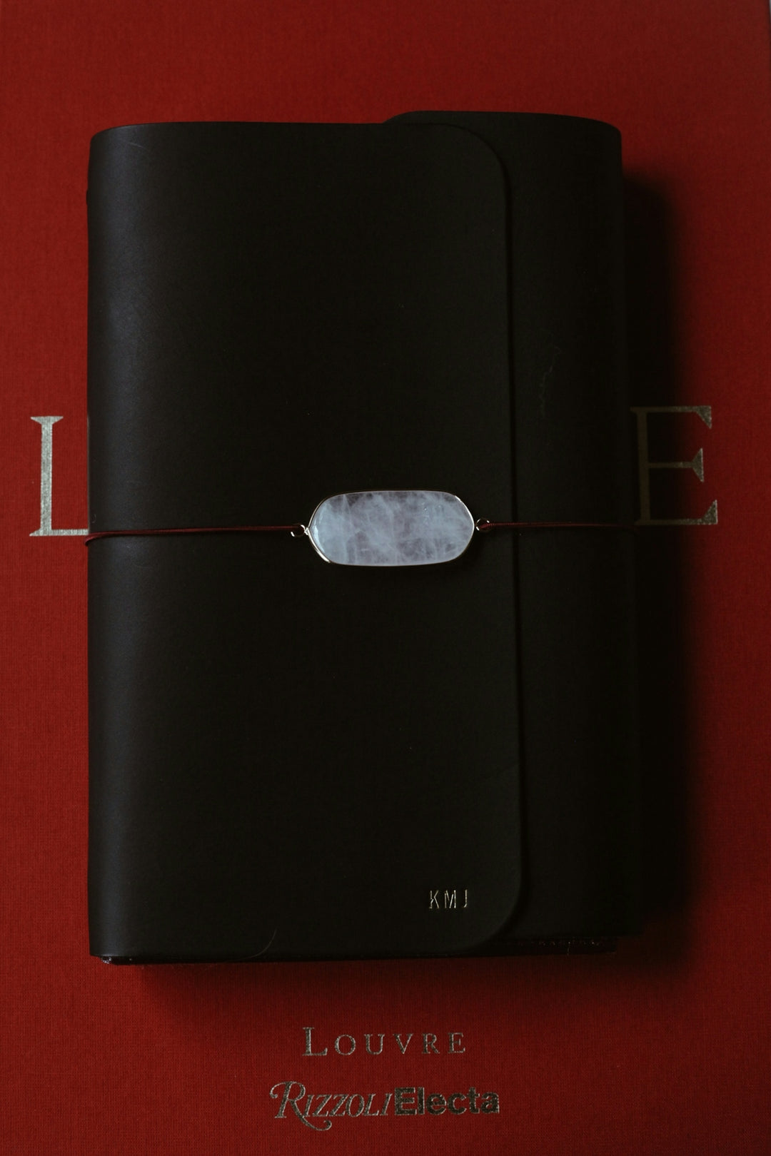 A red book with a black cover and a string attached to it