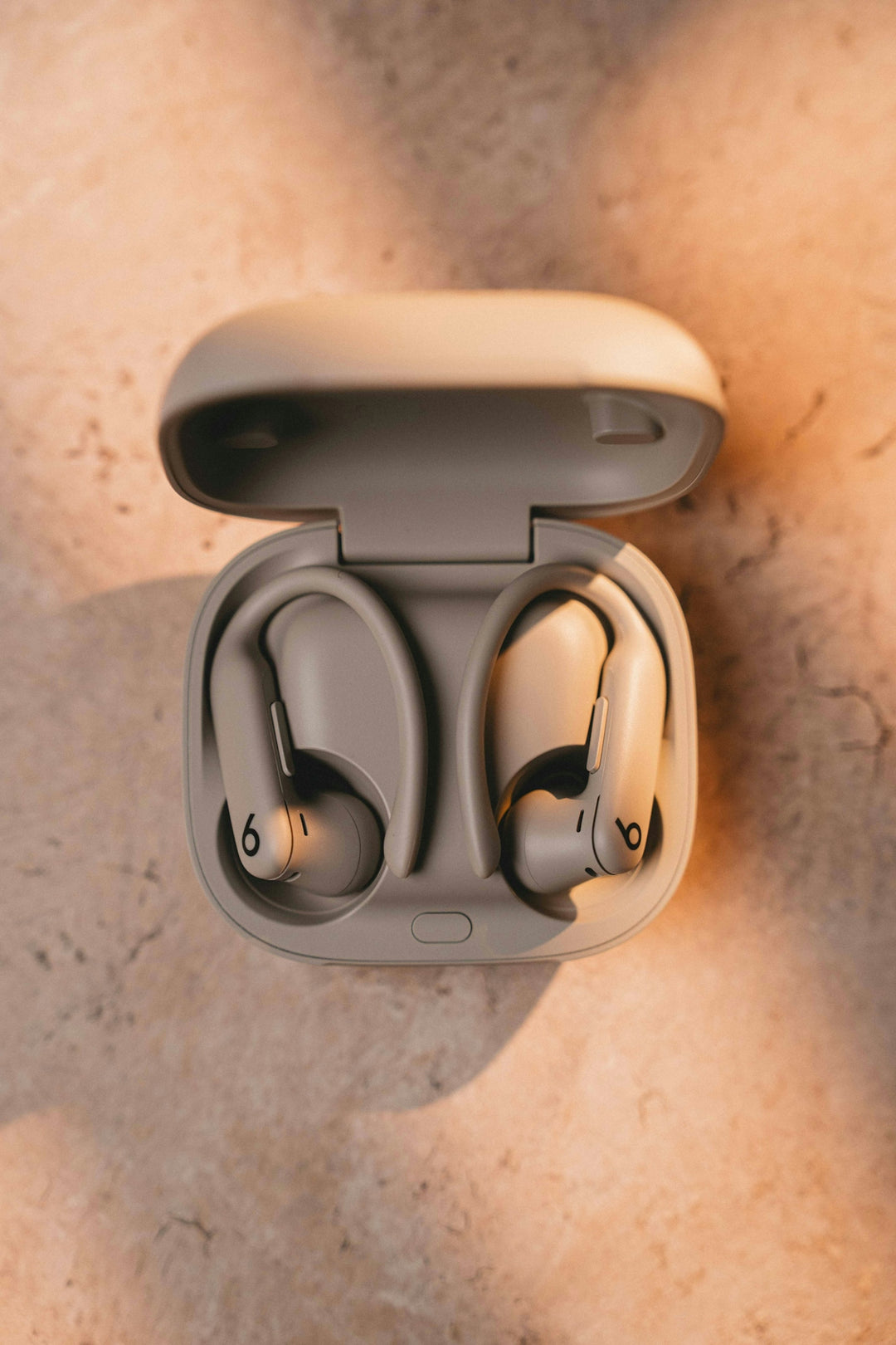 Beats fit pro earbuds sit in their charging case.