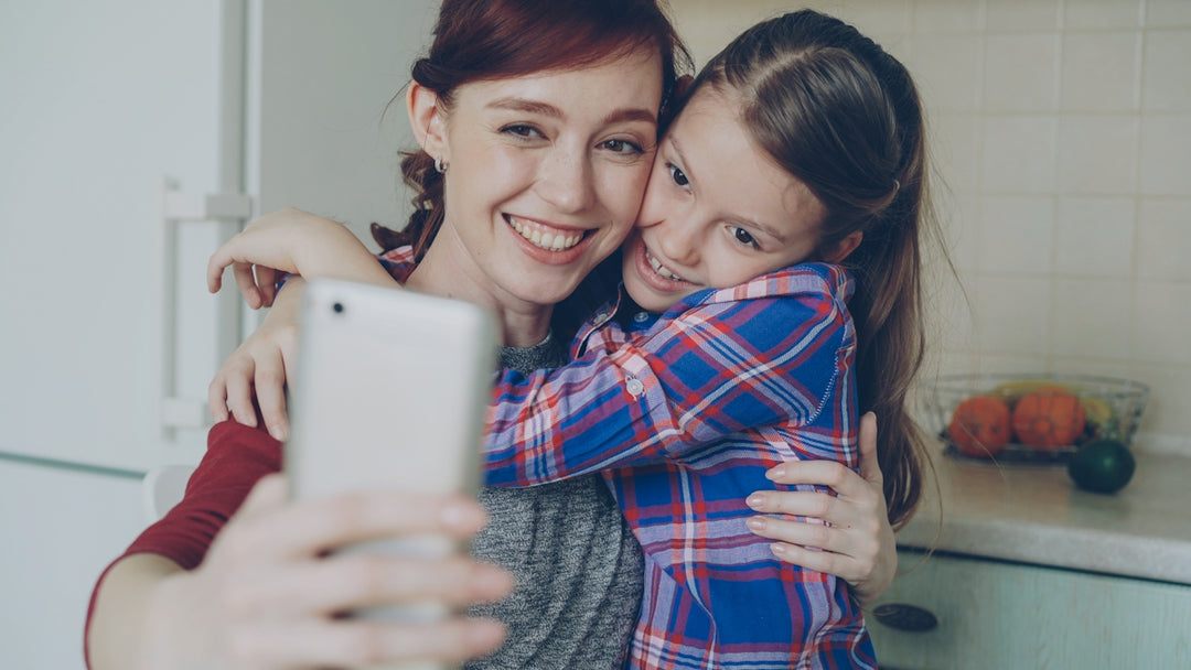 Mother and daughter happily take a selfie together.