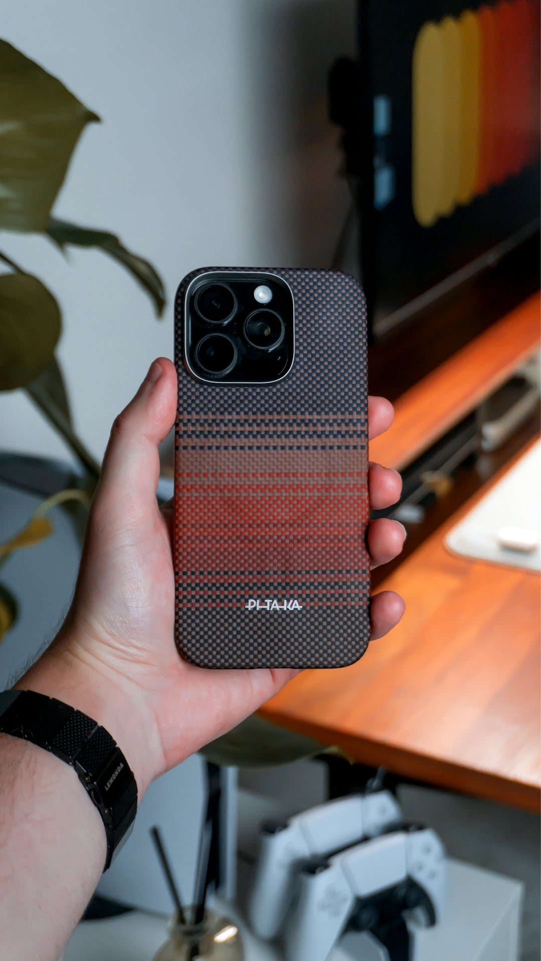 Hand holding a phone with a patterned case.