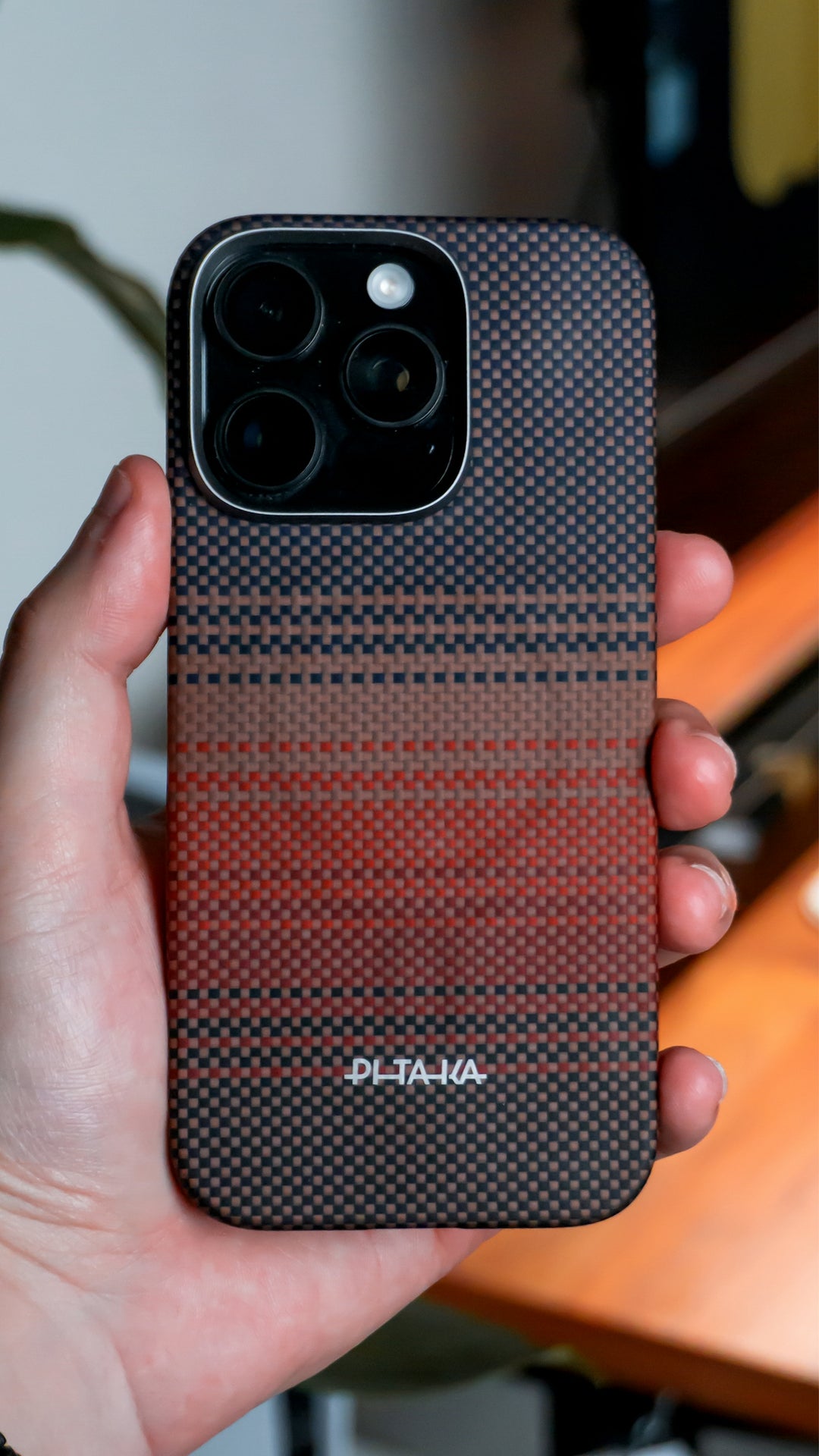 Hand holding a patterned iPhone with a unique case.