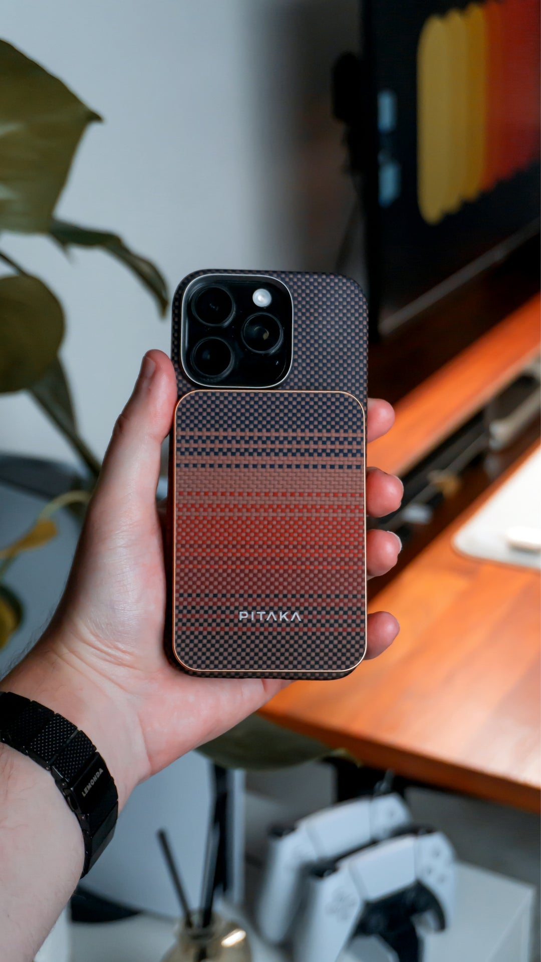 A hand holds a phone with a colorful case.