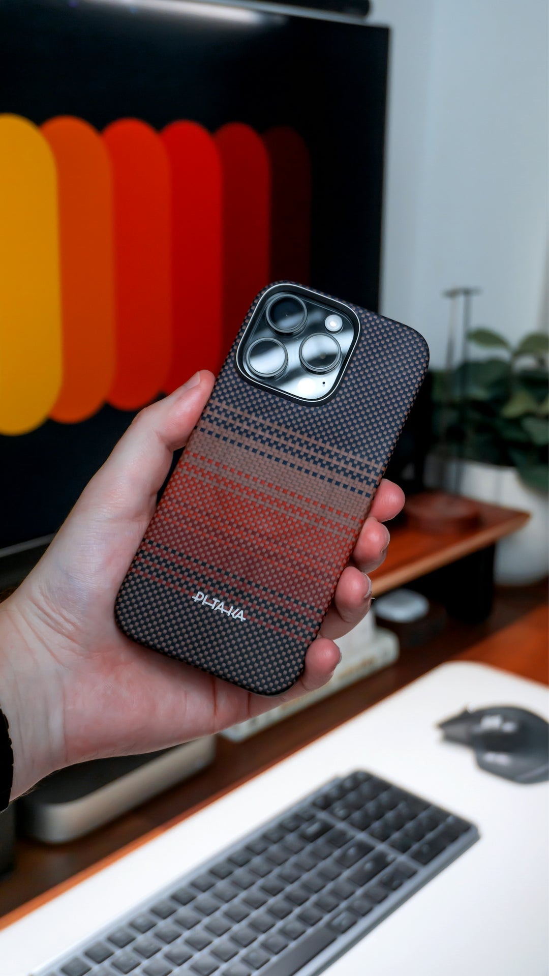 A hand holds an iPhone with a phone case.