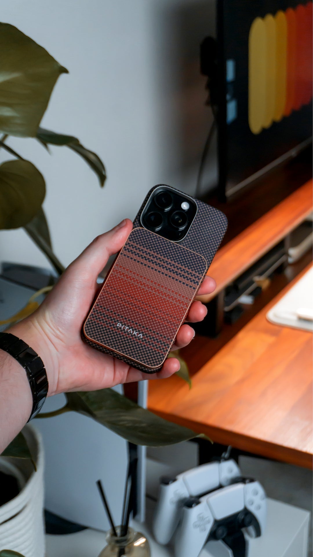 A hand holds an iPhone with a stylish case.