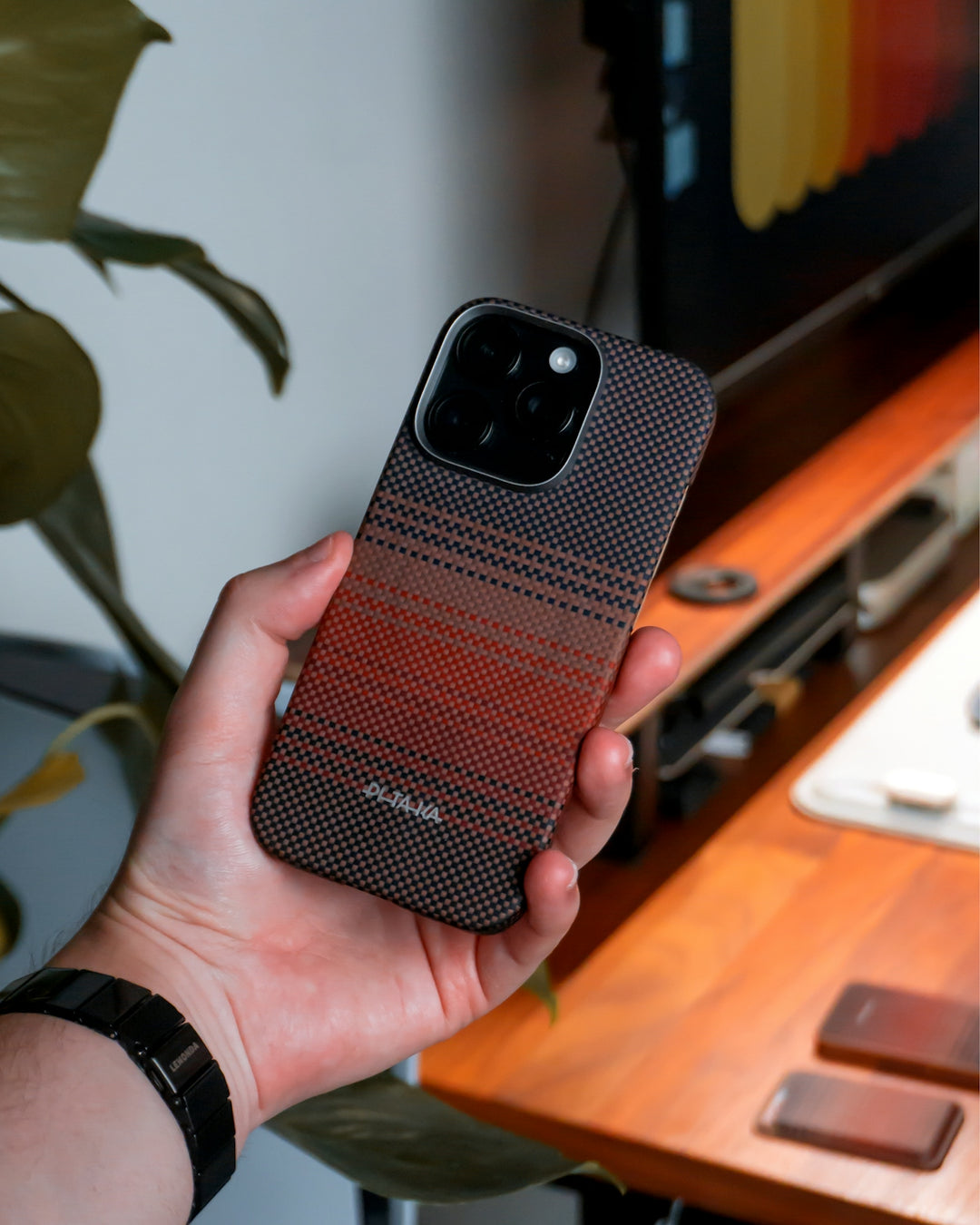 A hand holds an iPhone with an unique case.