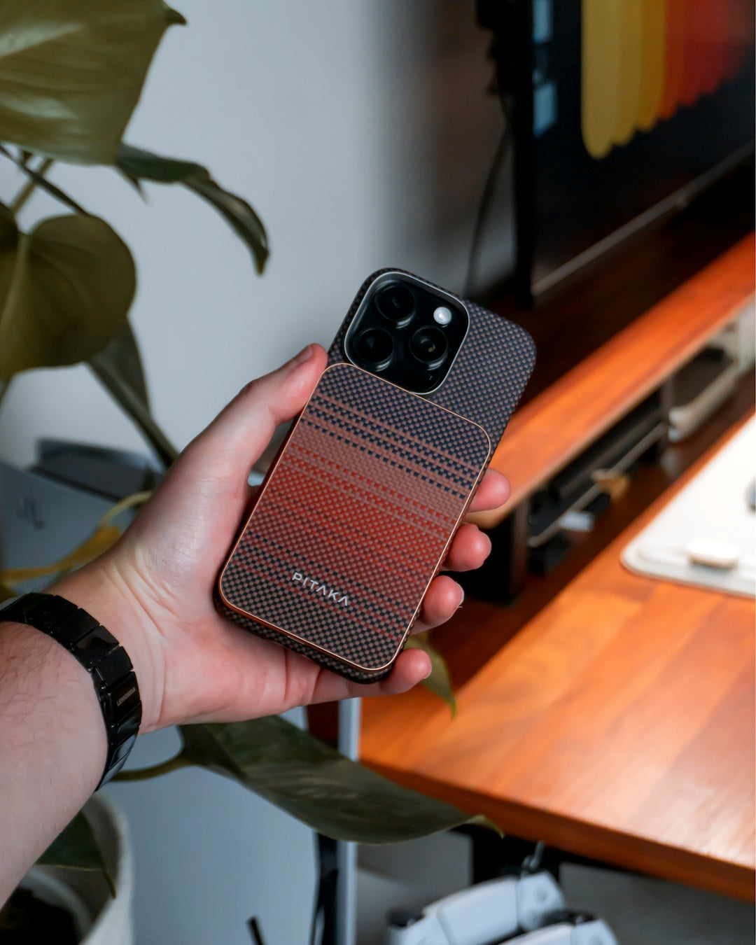A hand is holding a smartphone with a magsafe battery.
