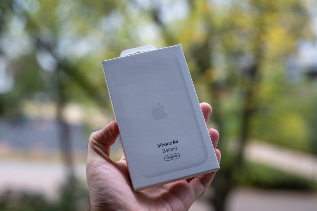 Hand holds white apple iPhone se box outdoors