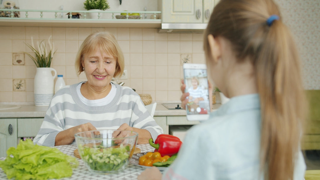 Grandmother and granddaughter making salad in kitchen