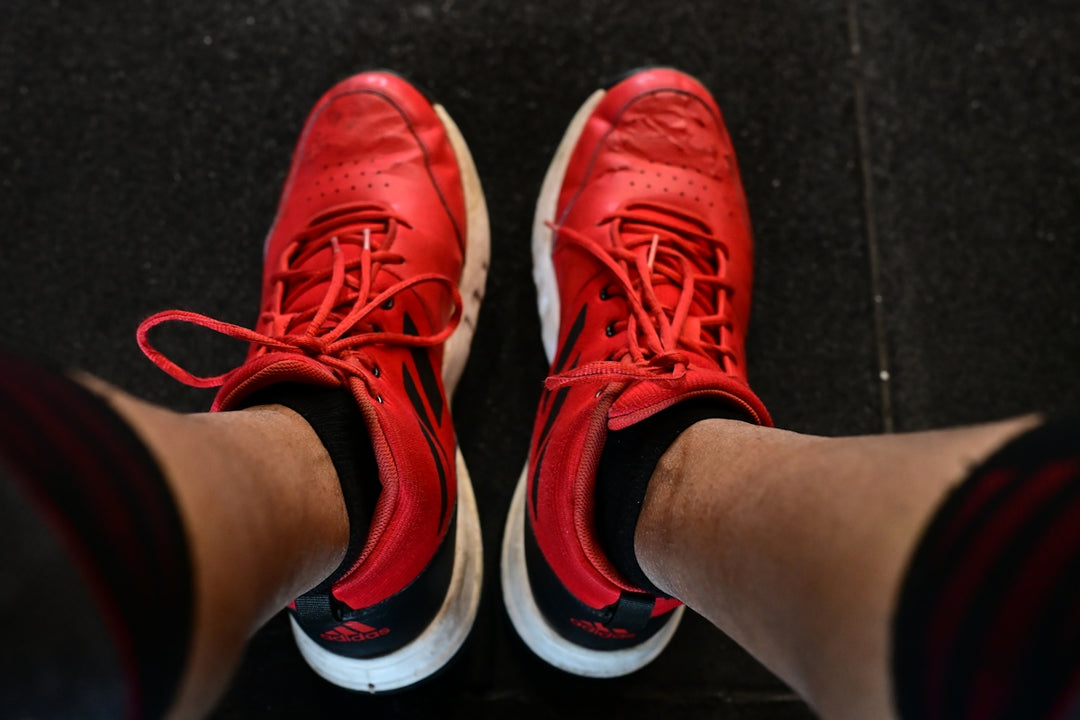 Pair of red athletic shoes with white soles.