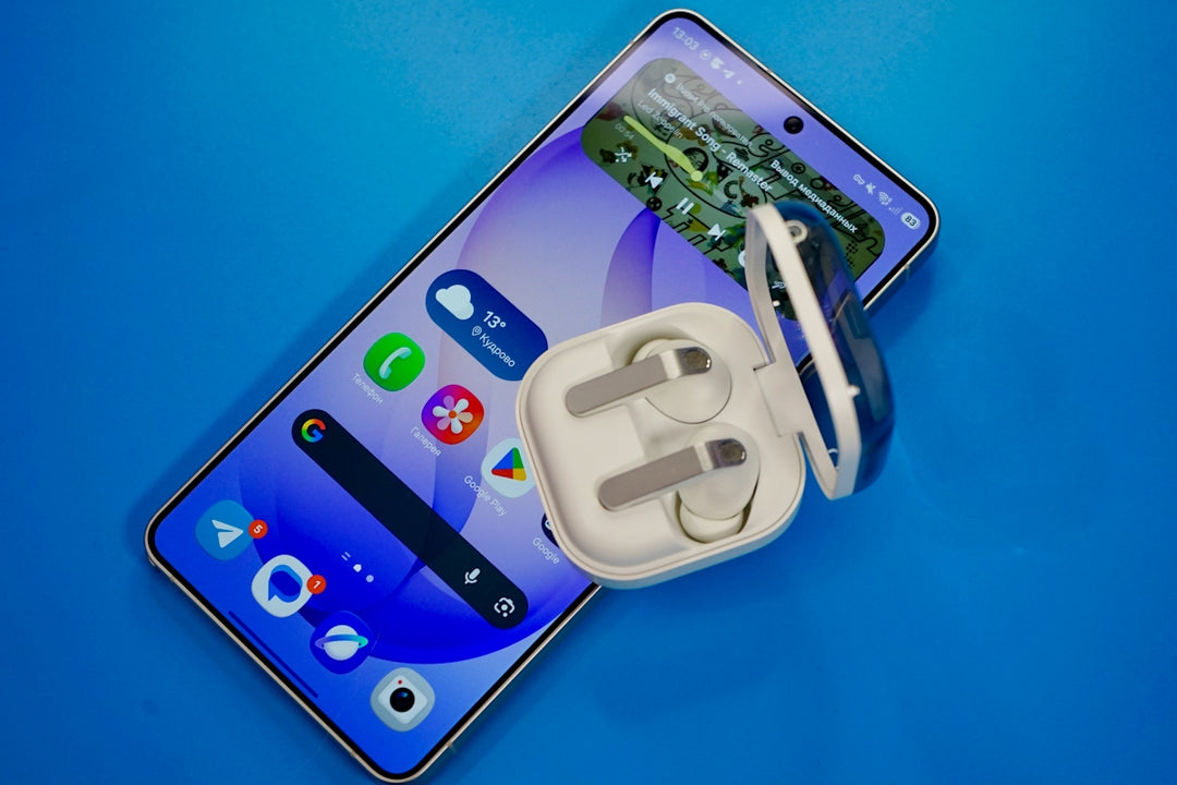Smartphone with wireless earbuds on blue background