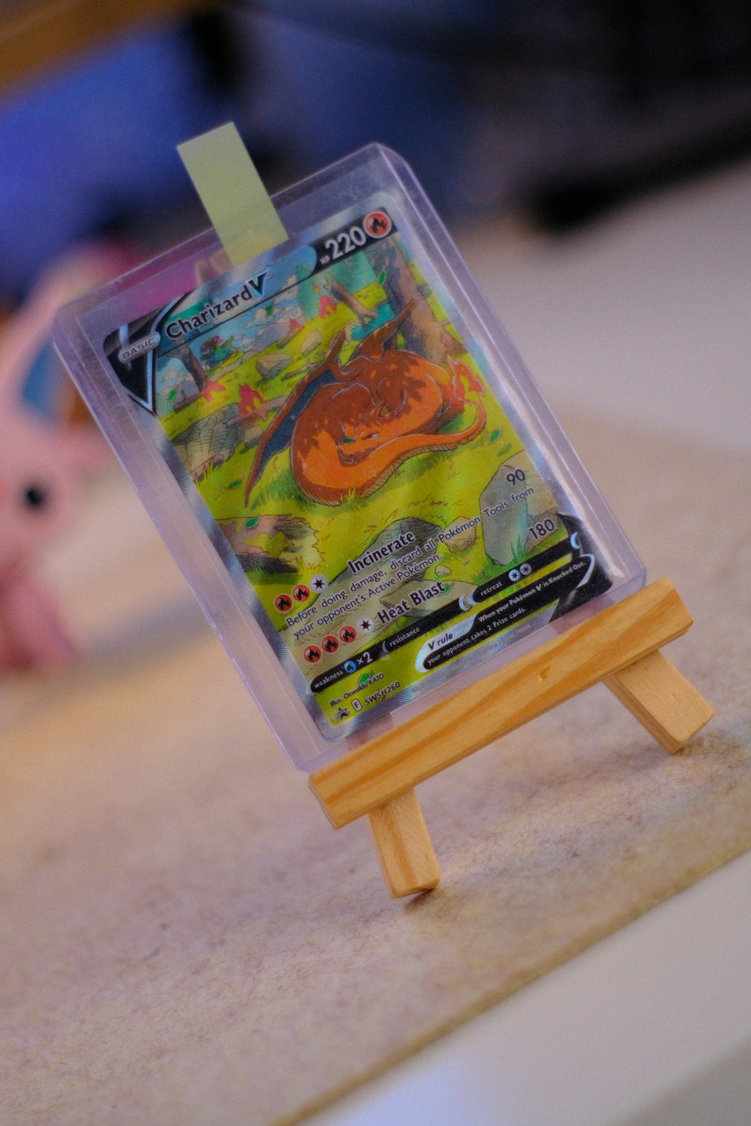Charizard v pokémon card on a wooden easel.