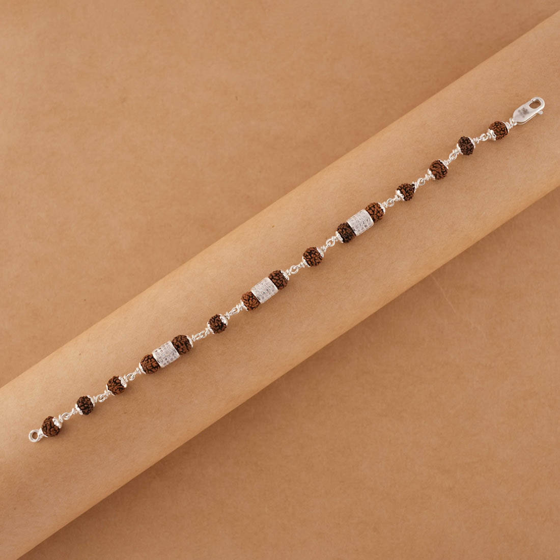 Silver Rakhi with Rudraksha and Three Diamond Cylinders