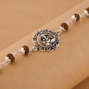 Silver Rakhi with Ganesh in a Designer Circular Sphere and Single Line Rudraksha