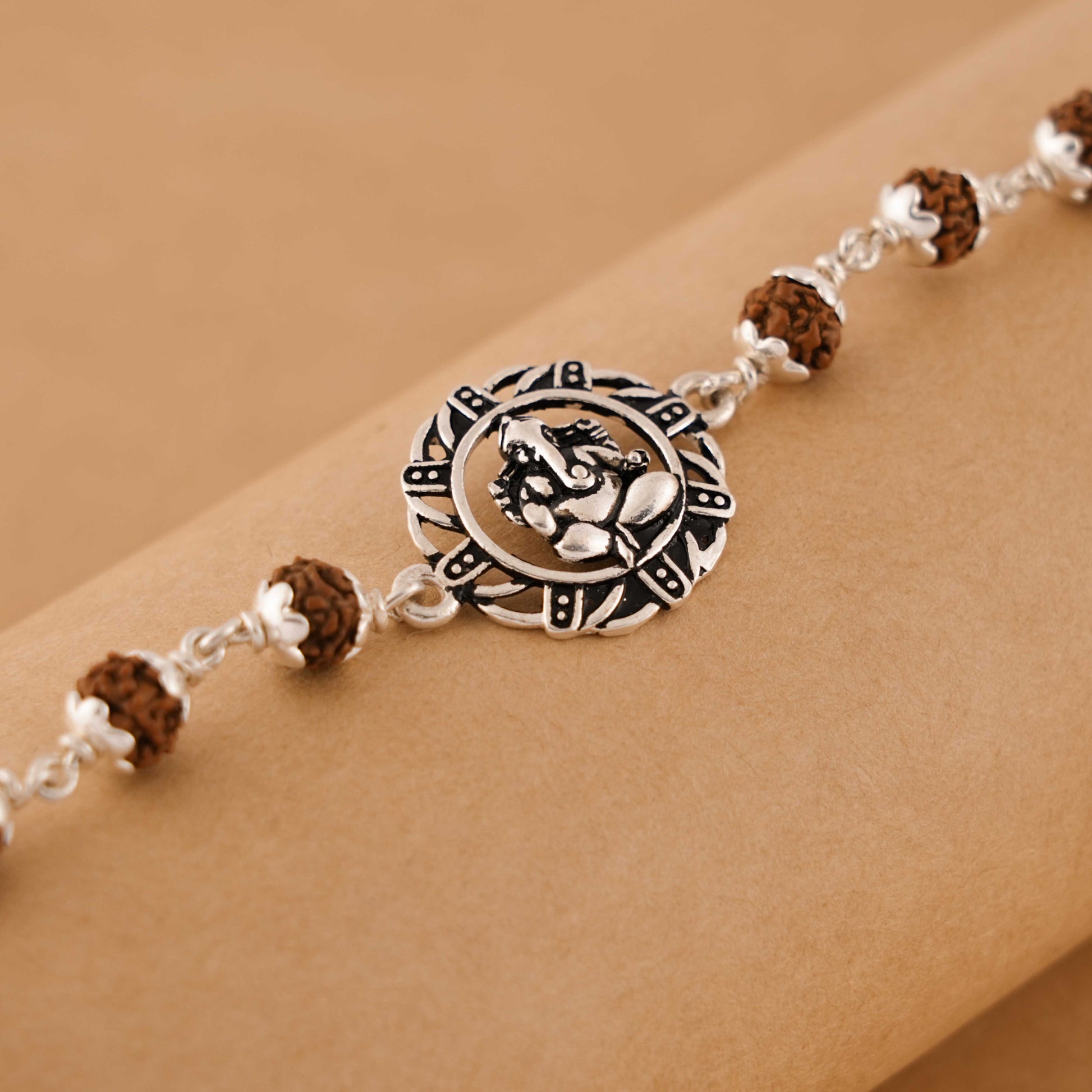 Silver Rakhi with Ganesh in a Designer Circular Sphere and Single Line Rudraksha