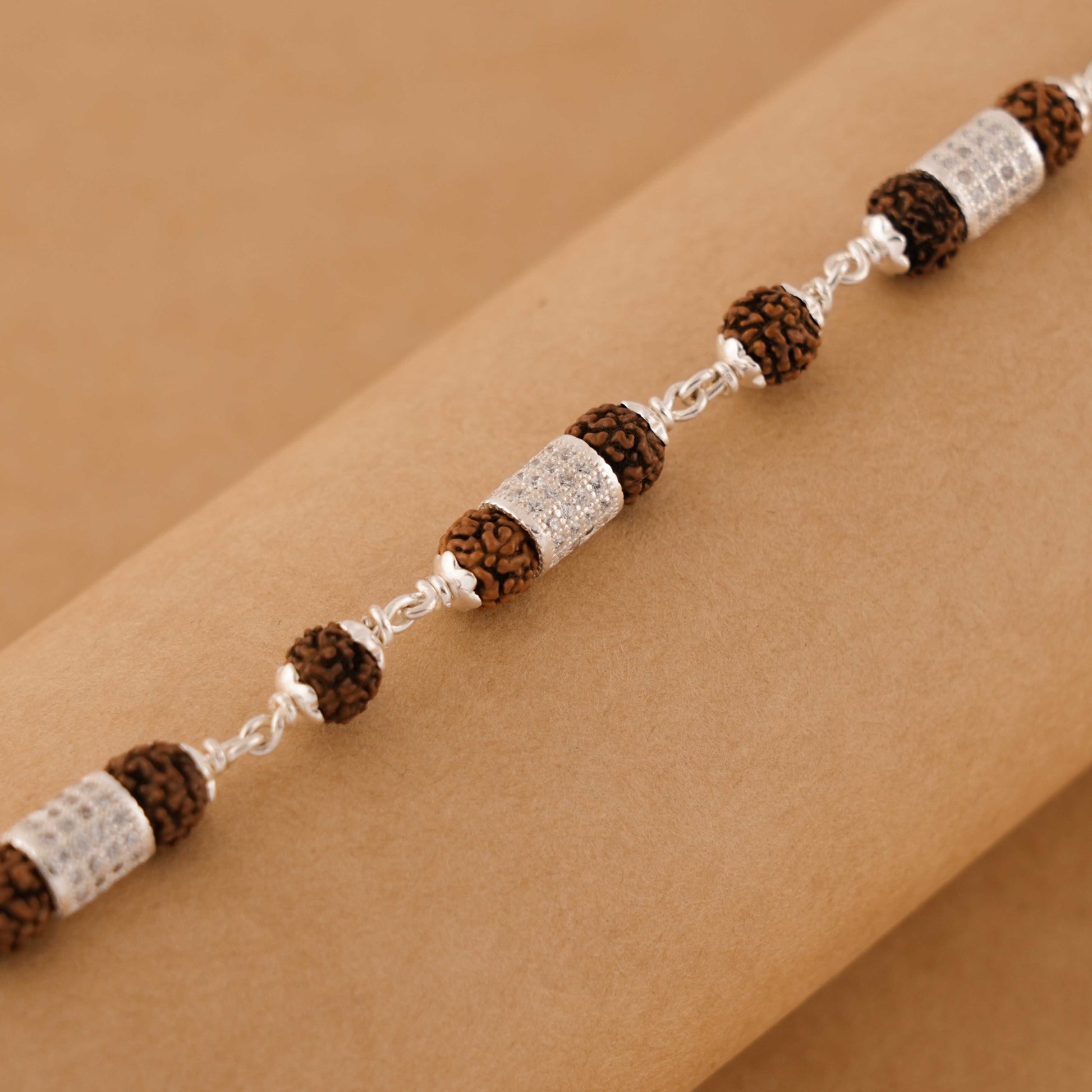 Silver Rakhi with Rudraksha and Three Diamond Cylinders