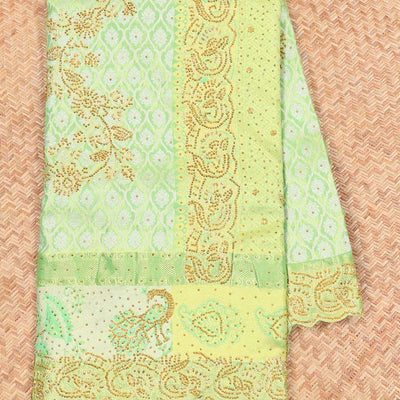 Green silk saree of ogee design with stonework, self curve border of peacock design & grand pallu embedded with stones