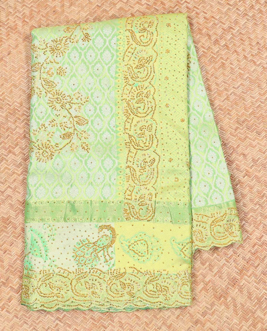 Green silk saree of ogee design with stonework, self curve border of peacock design & grand pallu embedded with stones