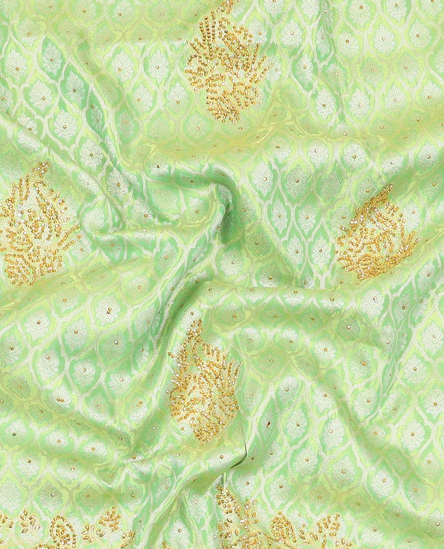 Green silk saree of ogee design with stonework, self curve border of peacock design & grand pallu embedded with stones