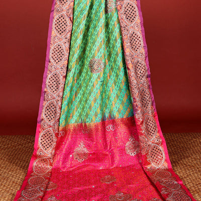 Green embossed vastrakala silksaree with ogee patterns & stonework, contrast cutwork border & intricate stonework pallu