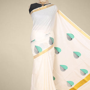 Cream kerala saree features thread embroidered leaf designs all over its body & pallu, zari border