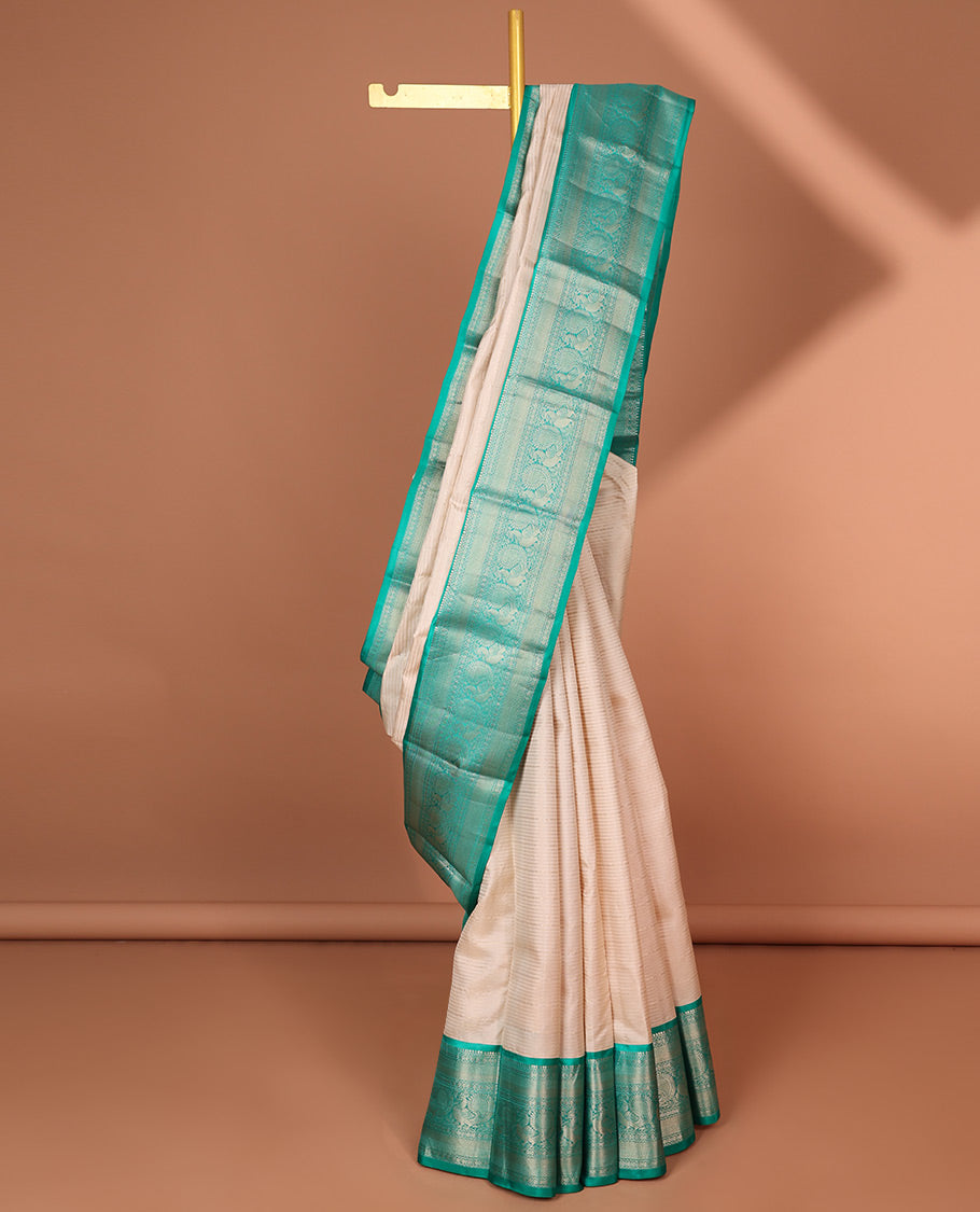 Cream striped silk saree with contrast border of thilakam mokku, mayil kann, mayil design & intricate zari design pallu